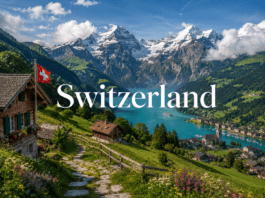 Snow-covered Swiss Alps with lakes, villages, and green meadows under sunlight